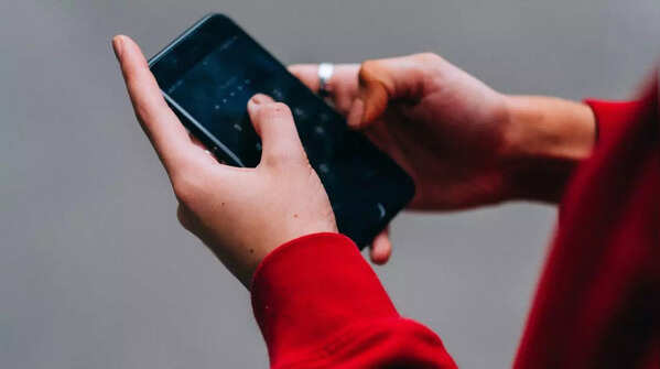 Person using both hands and thumbs to operate a phone