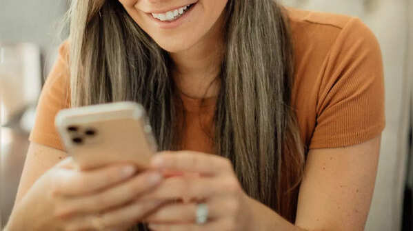 Person holding phone with both hands, scrolling with one thumb